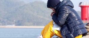 Eine Frau betet am Strand in der Nähe des Fährunglücks.