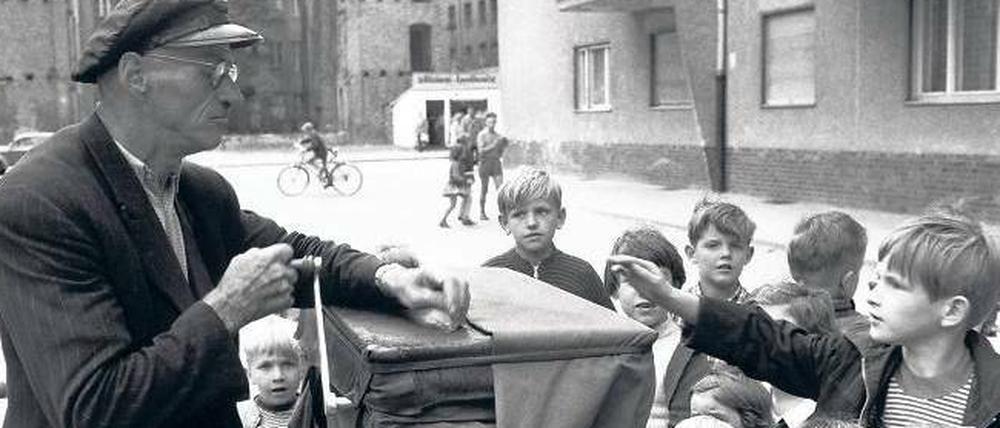 Melodie der Straße. Dieses Foto eines Leierkastenmanns, der 1958 Berliner Kinder unterhält, stammt aus dem „Berliner Liederbuch“.