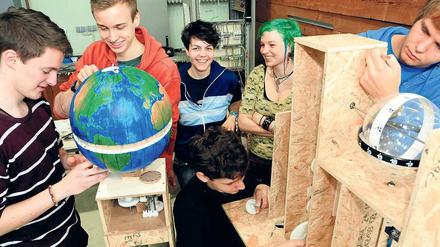Junge Männer und Frauen konstruieren im Studium generale an der Technischen Universität Uhrenwerke.