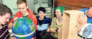 Junge Männer und Frauen konstruieren im Studium generale an der Technischen Universität Uhrenwerke.