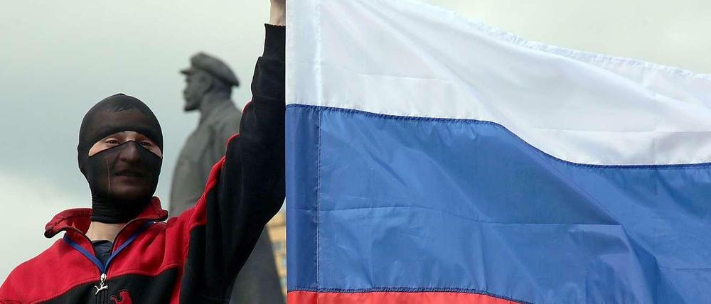 Ein prorussischer Aktivist hält eine russische Flagge hoch.