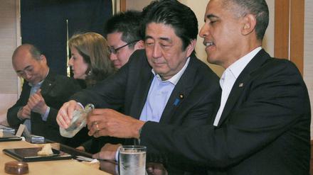 Japans Premier Abe schenkt Obama Reiswein ein.