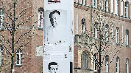 Vor einem Gebäude der Charité steht eine Gedenksäule mit Biografien von Mitarbeitern, die im Nationalsozialismus verfolgt wurden.