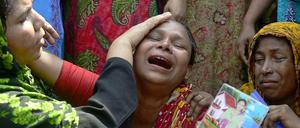 Eine Angehörige bricht am Jahrestag der Katastrophe auf der Trauerfeier zusammen.