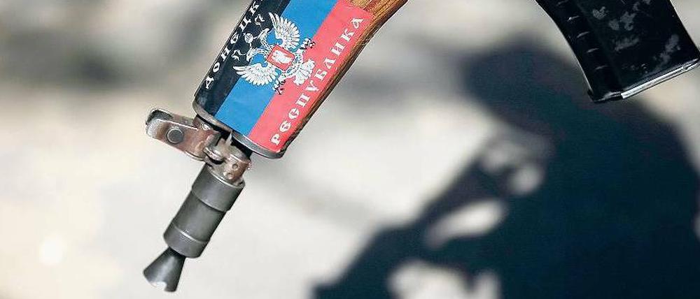Republik Donezk steht auf dem Gewehr eines prorussischen Rebellen in Slawjansk. 