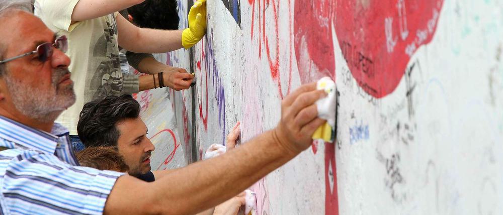 An der East Side Gallery macht Putzen Spaß. Mehrere 100 Berliner und Touristen reinigten am Sonntag mit Schwamm und Spüli einige Gemälde in der Nähe der Oberbaumbrücke. Quadratzentimeter um Quadratzentimeter ging es langsam voran. 