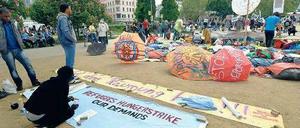 Mittendrin. Auf Transparente haben die bis vor kurzem noch hungerstreikenden Flüchtlinge am Oranienplatz ihre Forderungen geschrieben. Drumherum wird gefeiert. 