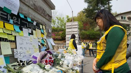 Stilles Gedenken. Eine freiwillige Helferin trauert an einem provisorischen Schrein vor der Schule in Ansan, welche die meisten Opfer des Fährunglücks besuchten.