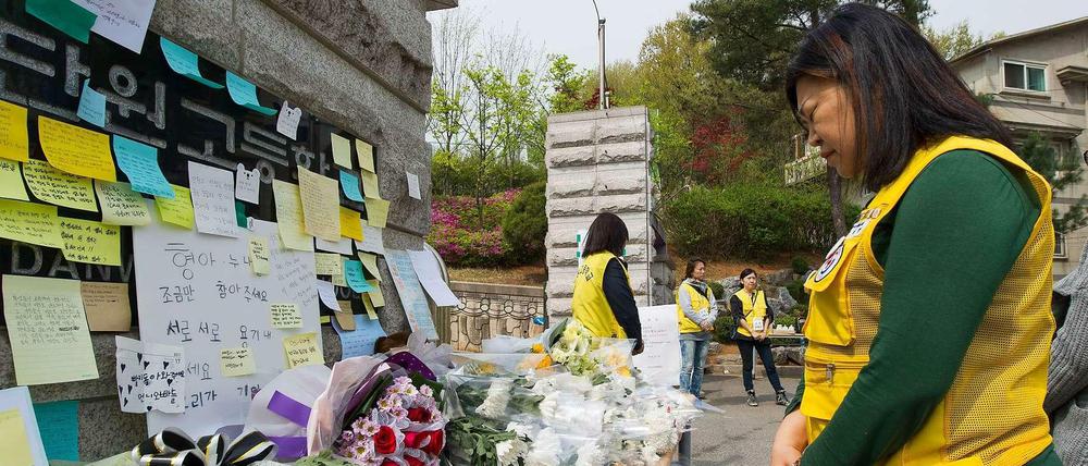 Stilles Gedenken. Eine freiwillige Helferin trauert an einem provisorischen Schrein vor der Schule in Ansan, welche die meisten Opfer des Fährunglücks besuchten.