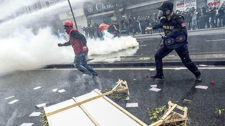 Ein türkischer Demonstrant rennt vor einem Polizisten in Istanbul davon. 