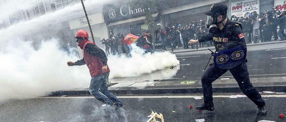 Ein türkischer Demonstrant rennt vor einem Polizisten in Istanbul davon. 