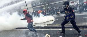 Ein türkischer Demonstrant rennt vor einem Polizisten in Istanbul davon. 