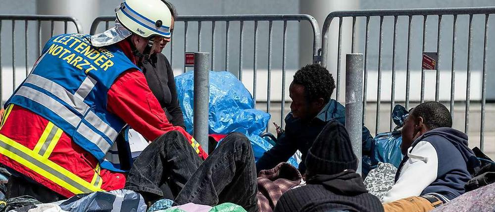 Ein Notarzt kümmert sich am Mittwoch am Alexanderplatz um einen hungerstreikenden Flüchtling.