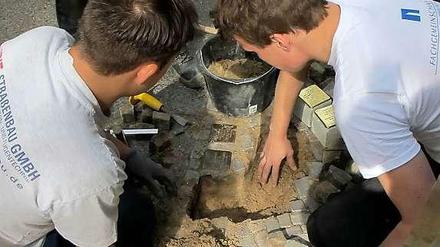  Auszubildende des Bauhofs Lichterfelde setzten die Stolpersteine in der Westfälischen Straße ein.