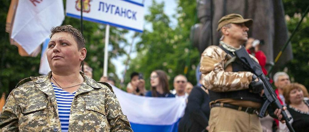 bewaffnete prorussische Aktivisten bewachen eine Siegesfeier nach dem Referendum in Lugansk.