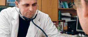 Arzt beim Messen des Blutdrucks