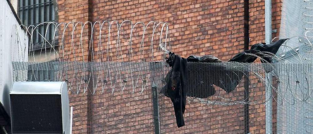Zerfetzte Jacke auf dem Sicherheits-Draht an der JVA Moabit: die Fahndung nach den zwei flüchtigen Häftlingen läuft auf Hochtouren.