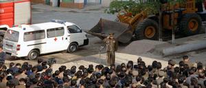 Dieses Pressefoto zeigt nach offiziellen Angaben einen Offizier, der sich bei Anwohnern in Pjöngjang für den Einsturz des Hauses entschuldigt.