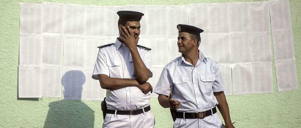 Zwei Polizisten vor einem Wahllokal. Hinter ihnen ist der Stimmzettel zu sehen. Er könnte kürzer sein, denn der Wahlsieger steht schon fest: General Abdel Fattah al Sisi wird der nächste Präsident Ägyptens sein. Die einzigen, die ihm Konkurrenz machen könnten, sind die Muslimbrüder, und die sind zur Wahl nicht zugelassen.