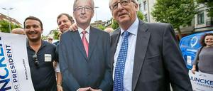 Ironie im Wahlkampf. Die Unterstützung der Kanzlerin für Juncker hält sich in Grenzen - trotzdem präsentiert der Kandidat einen Pappkameraden mit "Merkel-Raute". 