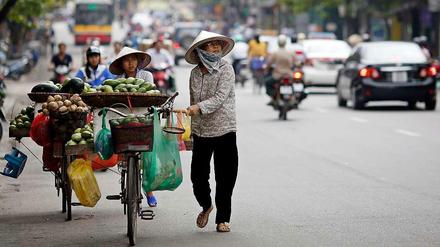 Händlerinnen auf einer Straße in Hanoi. Trotz Wirtschaftsboom ist das Einkommen in Vietnam sehr ungleich verteilt. Vor allem die Menschen auf dem Land haben zu kämpfen.