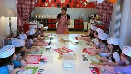 Aufmerksam lauschen die Kinder beim Backkurs den Erklärungen von Dagmar Thieme.