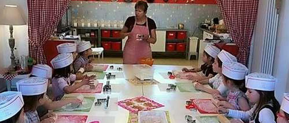 Aufmerksam lauschen die Kinder beim Backkurs den Erklärungen von Dagmar Thieme.