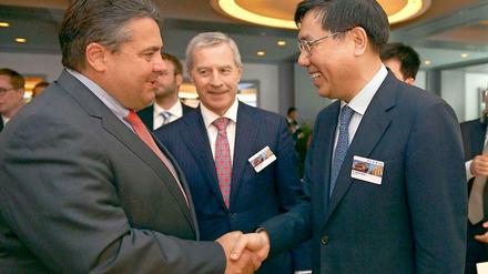 Minister Gabriel begrüßt den chinesischen Bankchef Jiang Jianquing.
