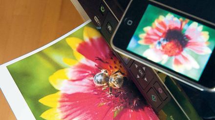 Immer in Verbindung. Die großen Druckerhersteller wie Canon oder Hewlett Packard bieten für mobile Geräte entsprechende Apps an, die auf Smartphones oder Tablets installiert werden.Foto: dpa