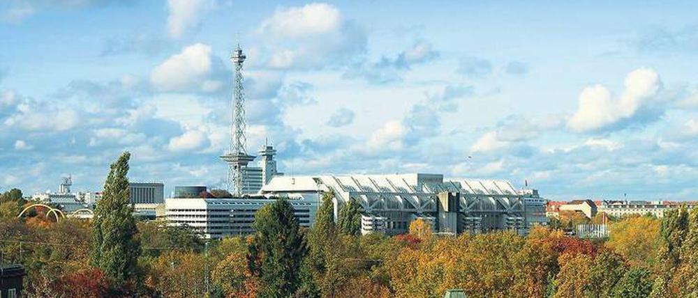 Über den Wipfeln. Das ICC, fotografiert von Halensee aus, mit Blick über die Bäume und die Kapelle des Friedhofs Grunewald.