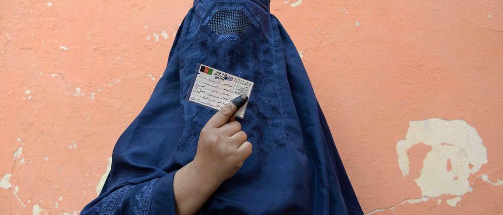 Eine afghanische Wählerin zeigt ihre Wahlkarte vor einem Wahllokal. 