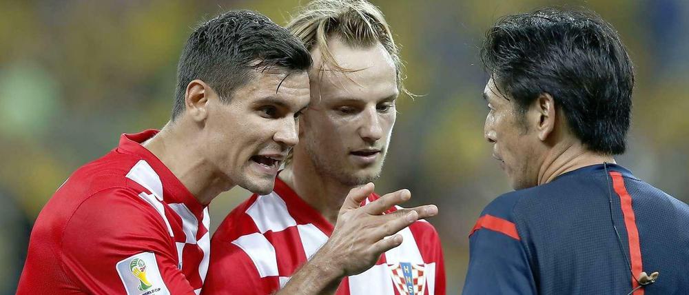 Die Kroaten Dejan Lovren (l.) und Ivan Rakitic im Gespräch mit Schiedsrichter Yuichi Nishimura.