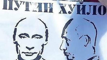 Wütende Proteste. Vor der russischen Botschaft haben Demonstranten ein Schmähplakat mit dem Gesicht des russischen Präsidenten Putin angebracht. 