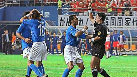 Saubermann auf Abwegen. Schiedsrichter Moreno wird während des WM-Spiels Südkorea – Italien 2002 von den Italienern bedrängt, nachdem er Francesco Totti Gelb gezeigt hat.