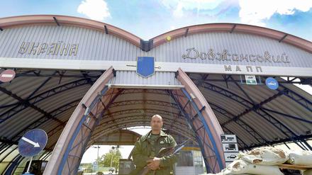 Ein Bewaffneter steht vor einem Grenzübergang zwischen der Ukraine und Russland.
