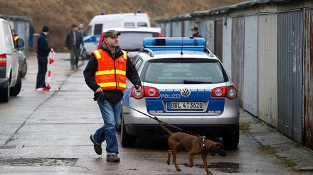 Ein Polizist untersucht mit einem Spürhund den Fundort der Babyleiche. 