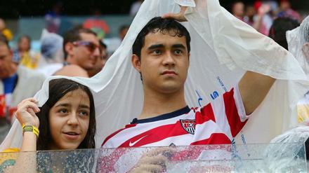 US-Fans schützen sich vor dem prasselnden Regen im Stadion. 