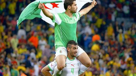 Ins Achtelfinale gesegelt. Die Algerier Essaid Belkalem (o.) und Abdelmoumene Djabou feiern den WM-Erfolg mit Fahnen.