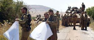Israelische Soldaten mit Landkarten beobachten die Grenze zu Syrien.