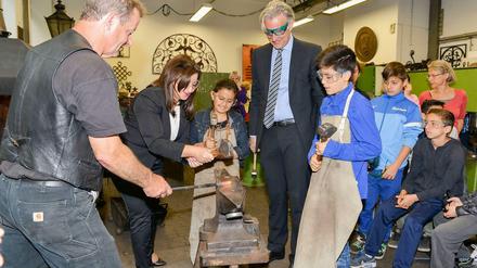 Senatorin Dilek Kolat mit Schülerin und Stephan Schwarz, Präsident der Handwerkskammer Berlin, in der Lehrschmiede des OSZ Konstruktionsbautechnik, das eine Schulpatenschaft mit der Otto-Wels-Grundschule eingeht..