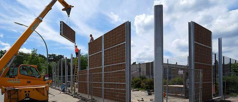 Plattenbau. Am Donnerstag wurden mit Kokosmatten verkleidete Schallschutzelemente an die Stahlträger der Wand in Dahlem moniert. Eine Begrünung soll folgen.