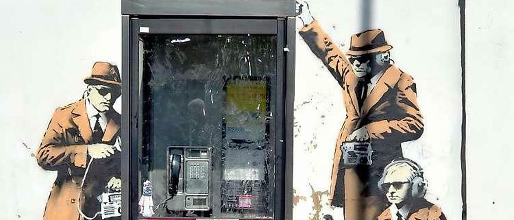 Immer gut verkabeln. Drei Geheimagenten auf einem im April 2014 im britischen Cheltenham entdeckten Wandgemälde, das vermutlich von dem Streetart-Künstler Banksy stammt.
