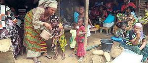 Immer die Hände waschen. Eine Mutter ermutigt ihr Kind in Macenta, Guinea. 