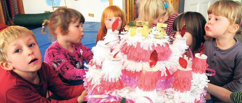 Kinder mit Geburtstagstorte aus Papier