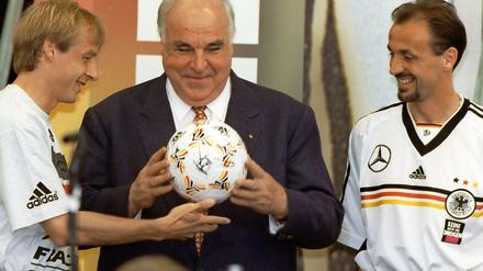 Jürgen Klinsmann und Jürgen Kohler überreichen Bundeskanzler Helmut Kohl einen Fußball mit Autogrammen der Mannschaft.