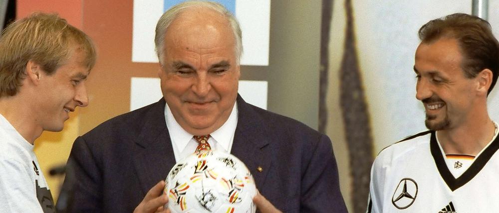 Jürgen Klinsmann und Jürgen Kohler überreichen Bundeskanzler Helmut Kohl einen Fußball mit Autogrammen der Mannschaft. 