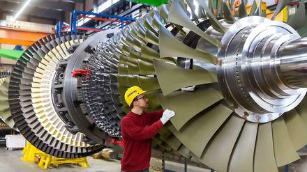 Ein Arbeiter kontrolliert eine Turbine, die bei Siemens in Berlin für ein Düsseldorfer Kraftwerk gefertigt wird. 