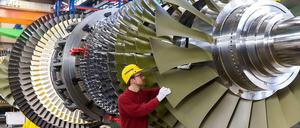 Ein Arbeiter kontrolliert eine Turbine, die bei Siemens in Berlin für ein Düsseldorfer Kraftwerk gefertigt wird. 