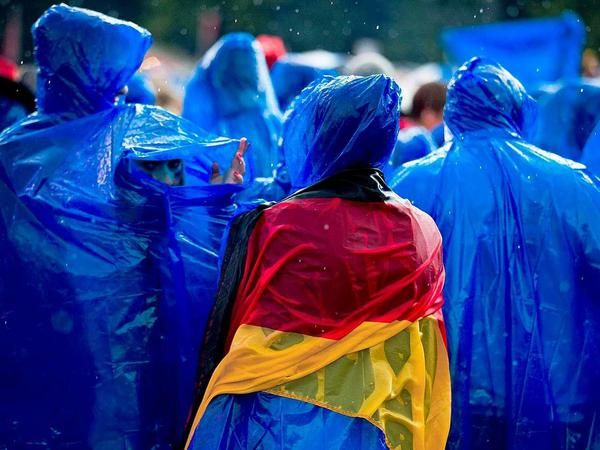 Deutsche Fans im Regen beim Public Viewing während der Fußball-WM.