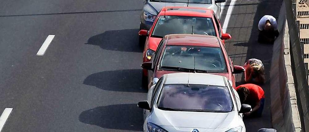 Taxifahrer suchen während eines Luftalarms in Tel Aviv Schutz neben ihren Fahrzeugen.